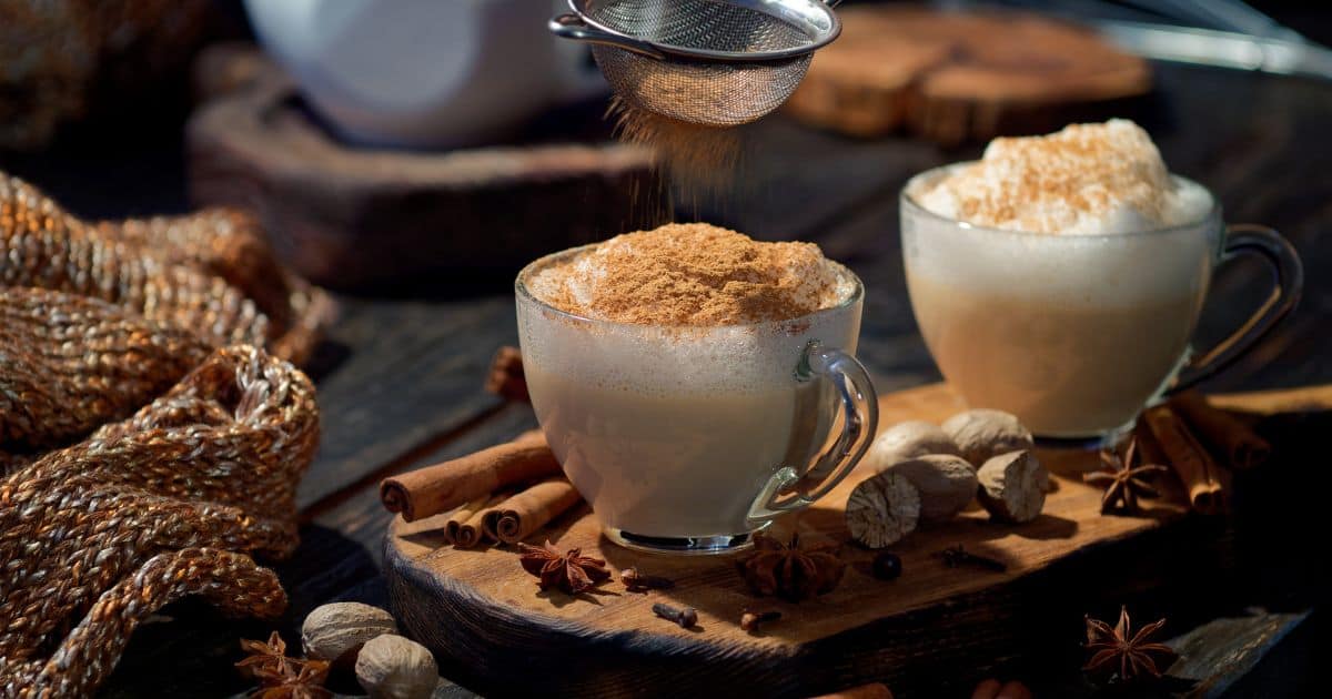 Chai latte surrounded by whole chai spices