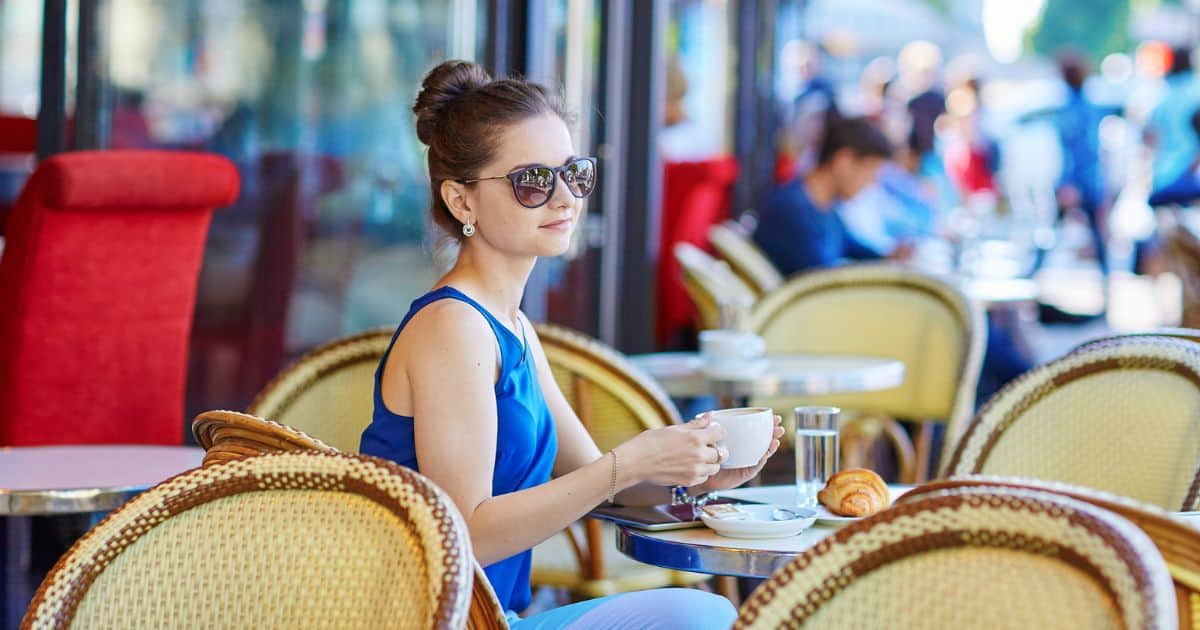 Women sitting in a Parisian cafe sidewalk with french roast coffee and croissant