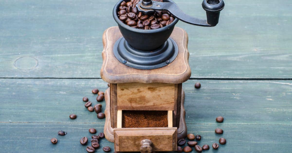 Homemade crank style coffee grinder with small wooden box to catch coffee grounds